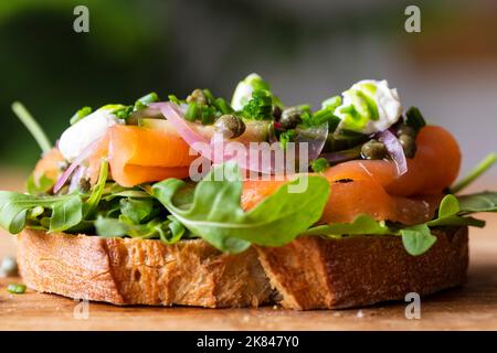 Sandwich ouvert avec saumon fumé, oignons marinés, crème sure et câpres Banque D'Images