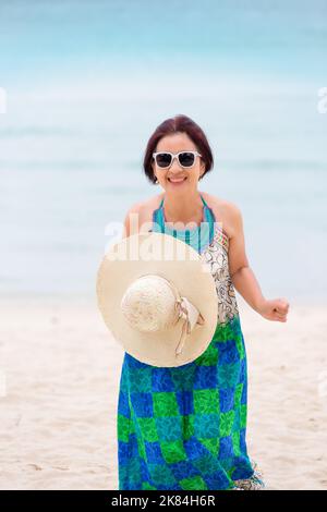 Femme asiatique d'âge moyen se détendant à la plage de chaweng à koh samui, en Thaïlande. Banque D'Images