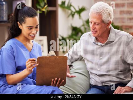 Oui, je voulais vous laisser quelque chose. Une infirmière qui se charge de la paperasserie avec son patient âgé. Banque D'Images