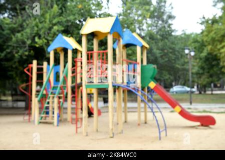 Vue floue sur l'aire de jeux moderne pour enfants dans le parc de la ville Banque D'Images