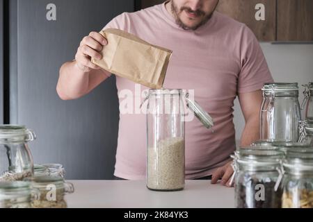 latins méconnaissables remplissant un pot de riz basmati dans un sac en papier. Banque D'Images