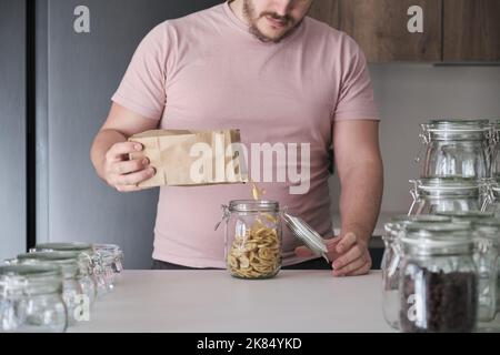 latins méconnaissables remplissant un pot de copeaux de banane d'un sac en papier. Banque D'Images