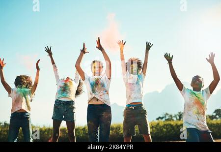 Être un enfant, c'est s'amuser. Un groupe d'adolescents s'amuser avec de la poudre colorée au camp d'été. Banque D'Images