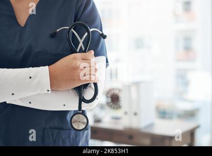 Je suis toujours à quelques pas d'un battement de coeur. Un médecin méconnaissable tenant un stéthoscope dans un bureau. Banque D'Images