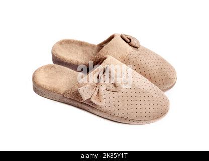 Paire de confortables pantoufles beige maison avec noeuds isolés sur fond blanc Banque D'Images