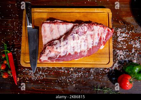 Viande crue. Côtes de porc brutes à partir du dos avec de la viande sur fond noir. Image d'arrière-plan, copier le texte d'espace Banque D'Images
