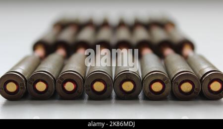 Macro-shot d'Une rangée de capsules de munitions dynamiques disposées dans l'ordre sur la surface blanche Banque D'Images