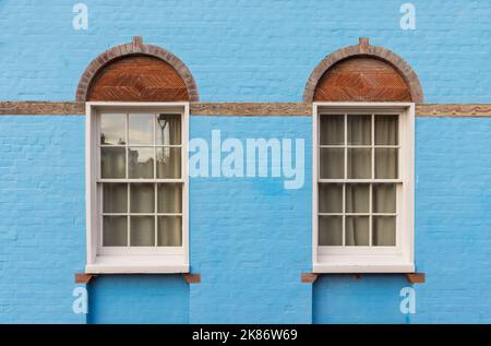 Côté d'une ancienne maison avec mur en brique bleue et fenêtres en bois blanc victorien. ROYAUME-UNI Banque D'Images