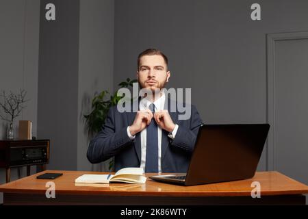 Homme d'affaires confiant et prospère travaillant sur un ordinateur portable au bureau. Concept multitâche Banque D'Images