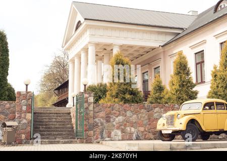 Bélarus, village Radzivilki, 01.05.22. Ancien manoir restauré Svyatsk Gkursky en Biélorussie. Escalier et entrée principale avec colonnes. Voiture rétro Moskvich-400 Banque D'Images