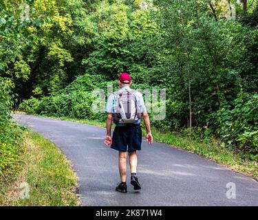 Un homme âgé marche sur la route de l'ancien mur de Berlin à côté du canal Britz, Baumschulenweg, Treptow-Köpenick, Berlin Banque D'Images