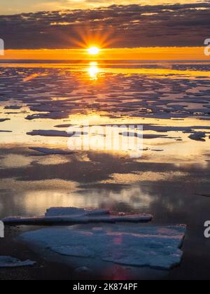 Coucher de soleil sur les bassins d'eau de fonte dans la glace épaisse du chenal McClintock, passage du Nord-Ouest, Nunavut, Canada, Amérique du Nord Banque D'Images