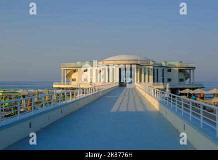 Rotonda al mare au lever du soleil à travers le ciel et la plage avec parasols, longue route à Senigallia, Italie Banque D'Images