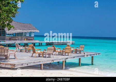 Terrasse de l'hôtel sur la plage d'une île des Maldives avec bungalow de conception typique pendant la journée Banque D'Images