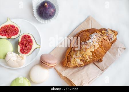 arrangement esthétique de figues, croissant d'amande et pâtes sur un fond blanc, vue de dessus Banque D'Images