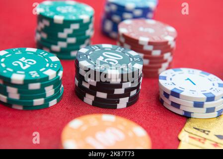 Quatre as près des piles de jetons sur une table en feutre rouge. Le jeu de poker est l'un des jeux de cartes les plus populaires dans le monde et a joué beaucoup dans les casinos. Carte Banque D'Images