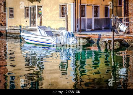 Bateau à moteur amarré le long du canal dans la ville de Chioggia, lagune vénitienne, province de Venise, quartier de Vénétie, nord de l'Italie - Europe Banque D'Images