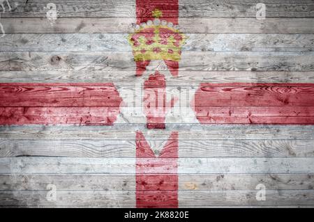 Une vignetted image de fond du drapeau de l'Irlande du Nord sur les planches de bois d'un mur ou le plancher. Banque D'Images