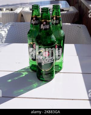 Trois bouteilles de bière grecque de Mythos vert en plein air par temps ensoleillé. Septembre / octobre 2022 automne Banque D'Images