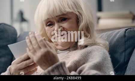bonne femme âgée atteinte de démence regardant la photographie imprimée Banque D'Images