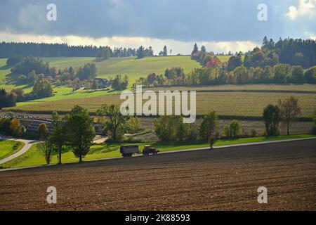 Tracteur sur le terrain. Belle nature d'automne avec paysage en République tchèque. Arbres colorés avec ciel bleu et soleil. Contexte pour l'automne et ag Banque D'Images
