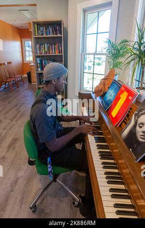 Highland Park, Michigan - Musanna Ali, 17 ans, joue le piano à la Maison du devoir. L'association aide les étudiants de cette communauté à faible revenu avec un tuteur Banque D'Images