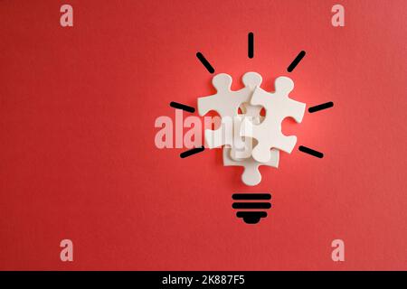 Ampoule de puzzles sur fond rouge avec espace de copie. Inspiration, concept d'idée créative. Banque D'Images