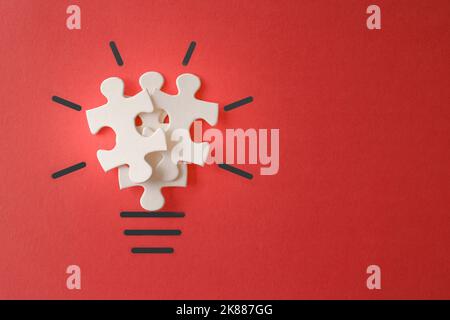 Ampoule de puzzles sur fond rouge avec espace de copie. Inspiration, concept d'idée créative. Banque D'Images