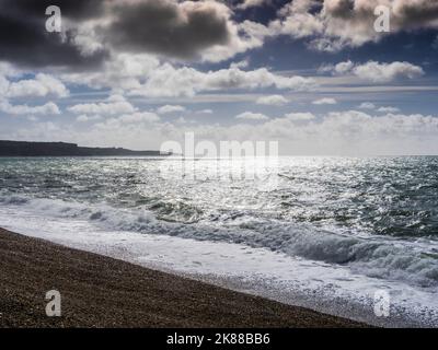 Une image de contre jour de nuages de tempête sur Chesil Beach à Dorset. Banque D'Images