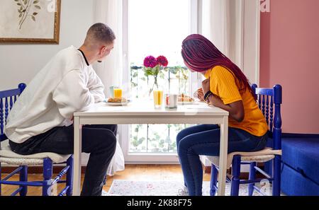 Couple multiracial prenant le petit déjeuner à la maison Banque D'Images