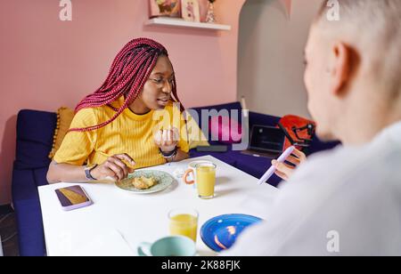 Joyeux couple multi-ethnique prenant le petit déjeuner à la maison Banque D'Images