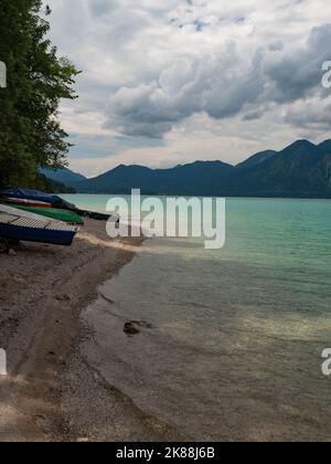 Bateaux à poissons empilés sur la côte de Walchensee. Le sommet de la montagne de Herzogstand reflète le niveau d'eau bleu vert. Saison d'été Banque D'Images