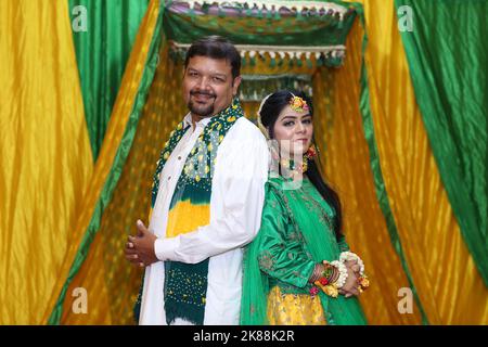 Mariée et marié à la cérémonie traditionnelle de Mayoon dans un lieu à la décoration colorée à Karachi, Pakistan Banque D'Images