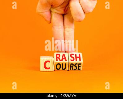 Symbole de trajectoire de collision. Concept Words Crash course sur cubes en bois. Belle table orange fond orange. Main d'homme d'affaires. Cours de crash d'affaires con Banque D'Images