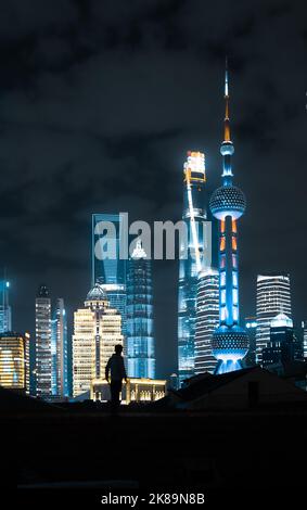 SHANGHAI, CHINE - 12 OCTOBRE 2022 - Un citoyen prend une photo de la tour de Lujiazui et d'autres monuments de nuit sur le vieux toit du Nord Banque D'Images