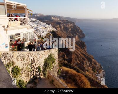 Restaurant avec vue sur la caldeira dans la ville de Fira au coucher du soleil. Île grecque des Cyclades de Santorin dans la mer Égée Banque D'Images