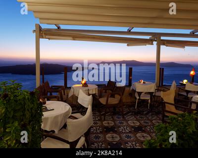 Restaurant avec vue sur la caldeira dans la ville de Fira au coucher du soleil. Île grecque des Cyclades de Santorin dans la mer Égée Banque D'Images