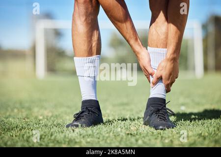 Sports, football et blessures de la cheville sur l'herbe avec auto-évaluation de la douleur physique au jeu d'athlète. Blessé, blessé et gêne articulaire de l'homme de football sur Banque D'Images