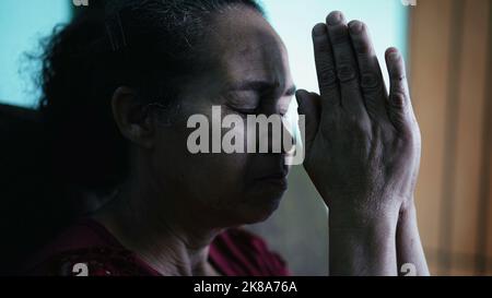 Une femme hispanique âgée priant à Dieu. Une personne religieuse sud-américaine plus ancienne Banque D'Images