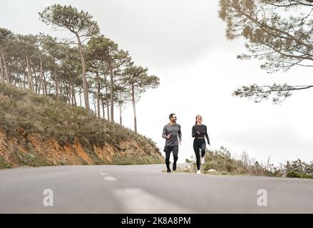 Ils commençaient à sentir que les coureurs sont élevés. Prise de vue en longueur de deux jeunes athlètes qui se rassemblent pendant une course en plein air. Banque D'Images