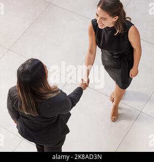 Ne laissez jamais tomber l'occasion de rencontrer d'autres Go-getters. Prise de vue en grand angle de deux femmes d'affaires qui se secouent la main dans un bureau. Banque D'Images