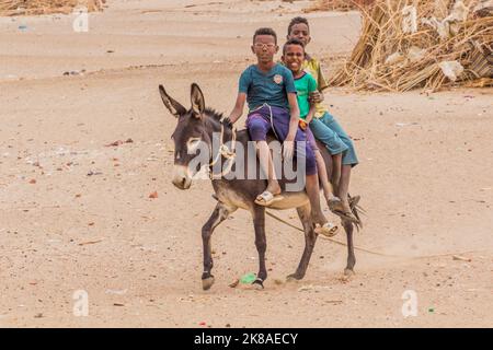 ABRI, SOUDAN - 26 FÉVRIER 2019 : des garçons de la région à cheval sur l'âne près d'abri, au Soudan Banque D'Images