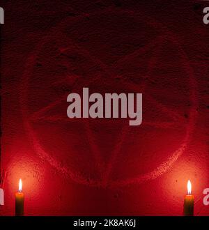 Symbole de pentagramme blanc sur un mur en béton. Autel satanique éclairé de bougies. Arrière-plan sombre. Occultisme effrayant et mystique Banque D'Images