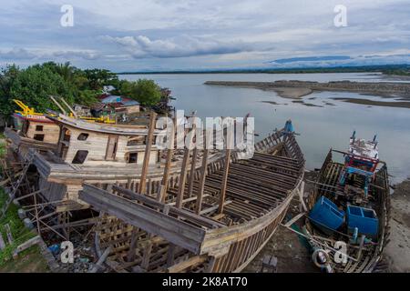 Aceh, Indonésie. 22 octobre 2022. Un chantier naval spécial pour les bateaux de pêche dans la zone de l'estuaire du village de Pusong, ville de Lhokseumawe. Les bateaux de pêche traditionnels sont construits en utilisant le bois comme matériau principal. Il n'y a pas d'activité de travailleur, ils sont en congé le week-end. Banque D'Images