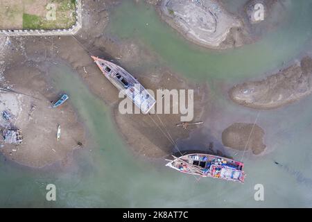 Aceh, Indonésie. 22 octobre 2022. Deux bateaux endommagés ont besoin d'être réparés et sont amarrés dans le sable avec des cordes de verrouillage. Les réparations ont été effectuées sur un chantier naval particulier pour les bateaux de pêche dans la zone de l'estuaire du village de Pusong, dans la ville de Lhokseumawe. Banque D'Images