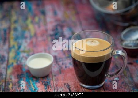 Americano avec la crème versée dans la boisson Banque D'Images