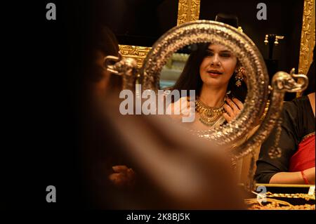 New Delhi, Inde. 22nd octobre 2022. Une femme essaie un collier d'or à l'occasion du festival Dhanteras à New Delhi. Les gens achètent des barres d'or, des ornements d'or, des pièces d'or des pièces d'argent ou des objets d'argent le jour de Dhanteras comme il est considéré qu'il apportera plus de richesse. (Image de crédit : © Kabir Jhangiani/ZUMA Press Wire) Banque D'Images