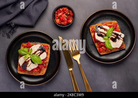 Photographie alimentaire de bruschetta, toast, fromage, mozzarella, tomate, basilic, balsamique Banque D'Images