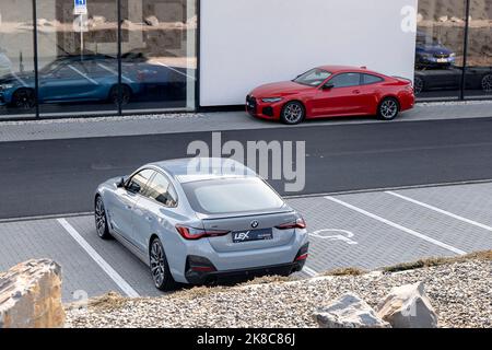 OSTRAVA, RÉPUBLIQUE TCHÈQUE - 1 MARS 2022 : BMW 420D devant le concessionnaire avec un coupé rouge à l'arrière-plan Banque D'Images