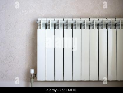 Radiateur de chauffage sur fond de mur lumineux, chauffe-eau blanc en métal dans la maison. Concept de chaleur, crise énergétique, économie, radiateur contemporain. Banque D'Images